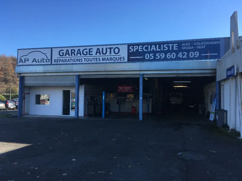 Façade du garage AP Auto avec ses portes d'atelier ouvertes